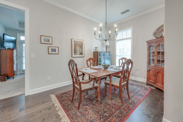 dining area with ornamental molding, dark hardwood / wood-style floors, and a chandelier