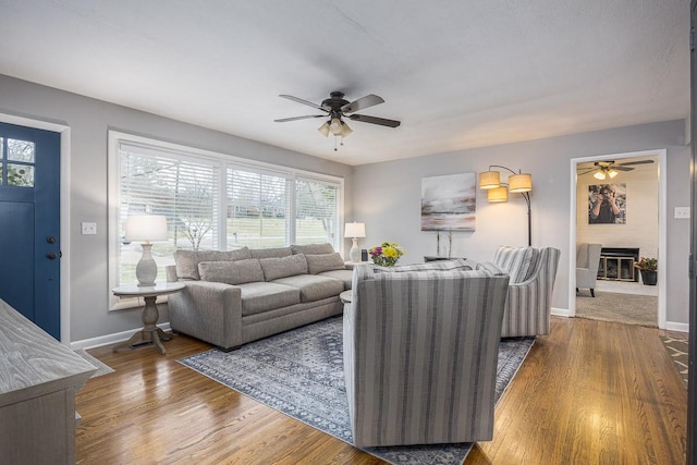 living room with wood-type flooring and ceiling fan