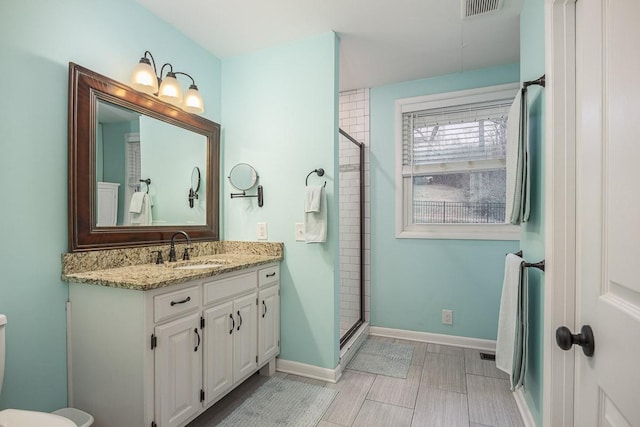 bathroom featuring vanity, an enclosed shower, and toilet