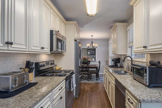 kitchen with sink, stainless steel appliances, tasteful backsplash, dark hardwood / wood-style flooring, and decorative light fixtures