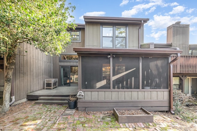 rear view of house featuring a sunroom