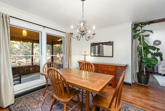 dining space featuring hardwood / wood-style flooring, ornamental molding, and a chandelier