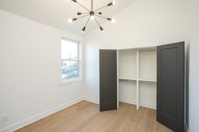 unfurnished bedroom with a closet, vaulted ceiling, and light hardwood / wood-style flooring