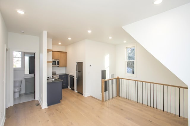 kitchen featuring a wealth of natural light, stainless steel appliances, and light wood-type flooring