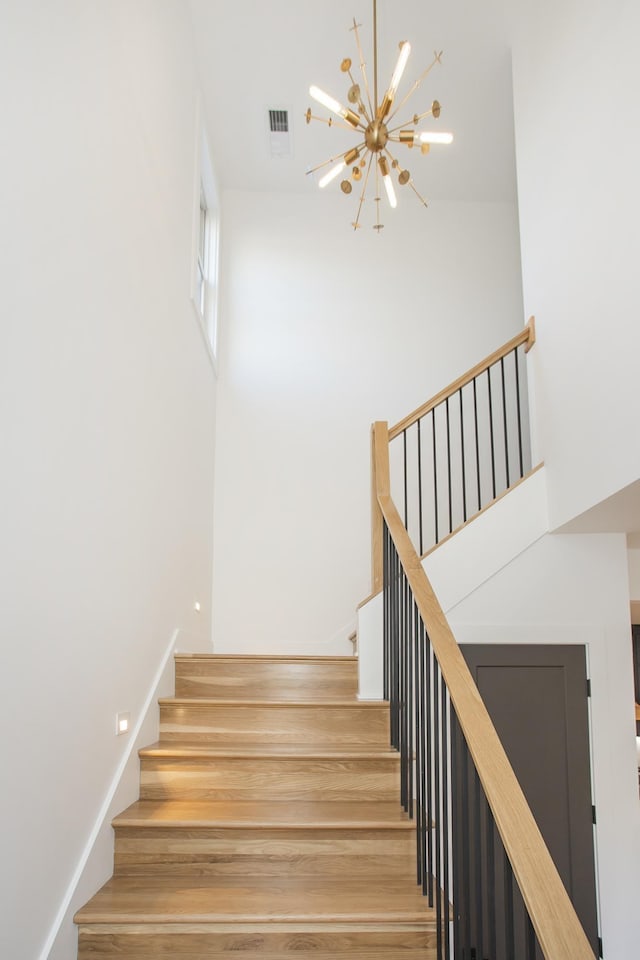 stairway featuring an inviting chandelier and hardwood / wood-style floors