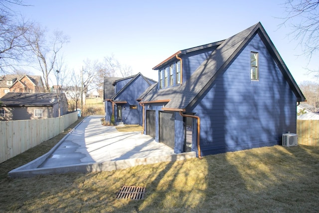 back of house with central AC, a patio, and a lawn