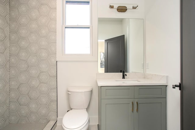 bathroom featuring vanity, a wealth of natural light, and toilet