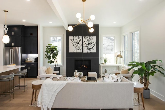 living room with baseboards, light wood-type flooring, a fireplace, beam ceiling, and recessed lighting