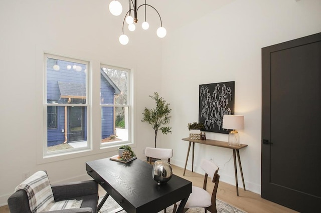 home office featuring an inviting chandelier, baseboards, and wood finished floors