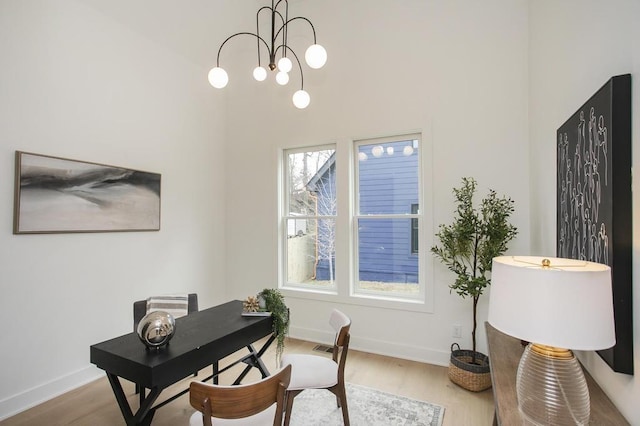 office area featuring light wood-style flooring, baseboards, and an inviting chandelier