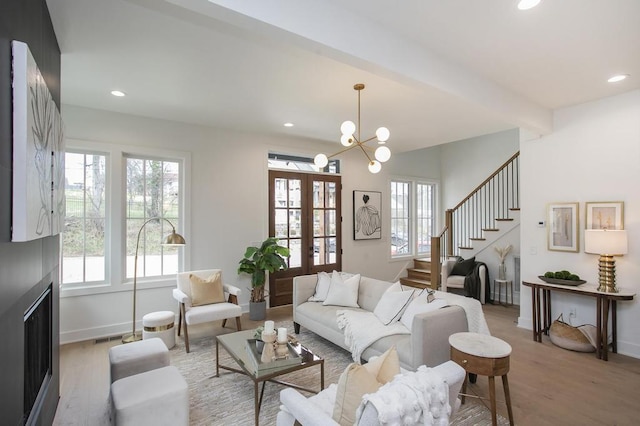 living area featuring stairs, light wood-type flooring, beam ceiling, and recessed lighting