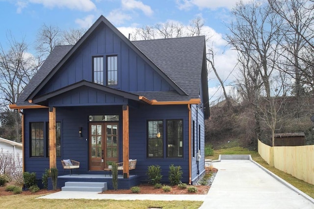 view of front of property featuring a shingled roof, fence, a porch, and board and batten siding