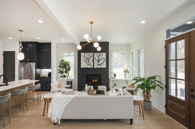 living room with recessed lighting, plenty of natural light, a fireplace, and light wood-style floors