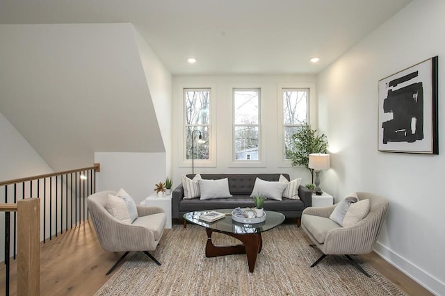 living area featuring baseboards, wood finished floors, and recessed lighting