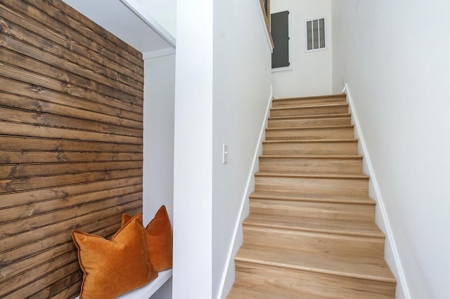 staircase with wood finished floors and visible vents