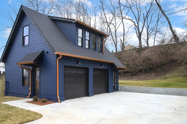 exterior space featuring a shingled roof, concrete driveway, and a garage