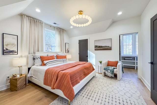 bedroom with lofted ceiling, light wood finished floors, visible vents, and recessed lighting