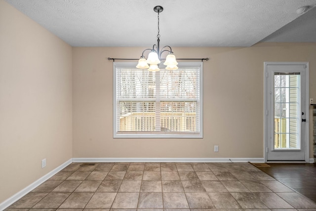 unfurnished dining area with an inviting chandelier and a textured ceiling