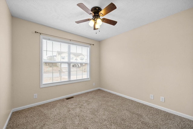 empty room featuring ceiling fan, a textured ceiling, and carpet flooring