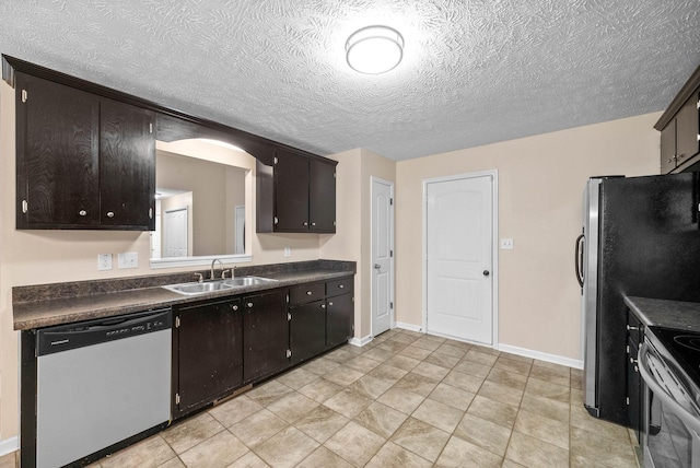 kitchen with dark brown cabinetry, sink, stainless steel appliances, and a textured ceiling