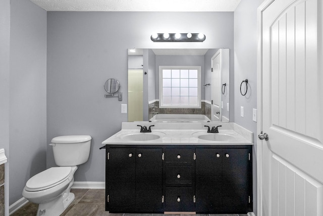 bathroom with tile patterned flooring, vanity, a tub, and toilet