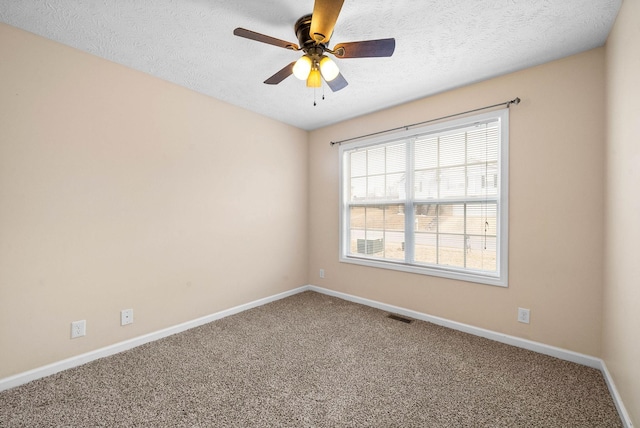 spare room featuring ceiling fan, carpet floors, and a textured ceiling