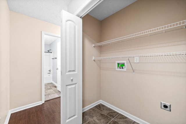 laundry room with hookup for an electric dryer, dark hardwood / wood-style flooring, hookup for a washing machine, and a textured ceiling