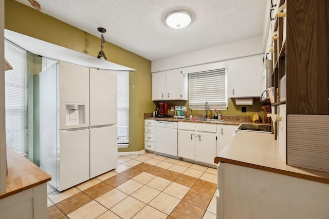 kitchen with white cabinetry, sink, white appliances, and light tile patterned floors