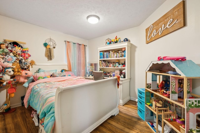 bedroom featuring a textured ceiling and dark hardwood / wood-style flooring