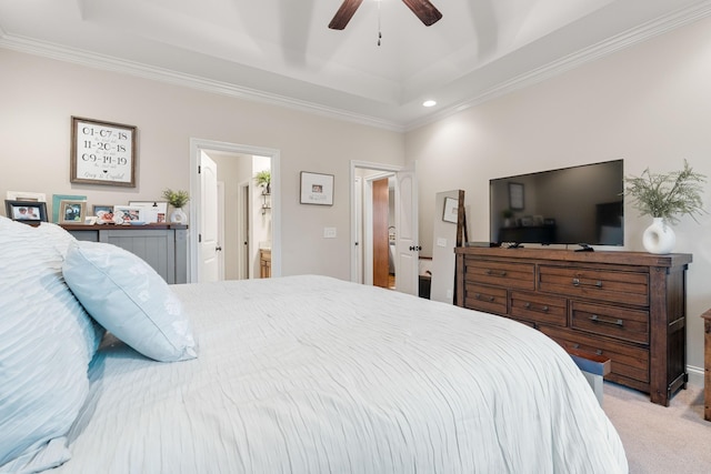 carpeted bedroom featuring ceiling fan, ornamental molding, a tray ceiling, and connected bathroom