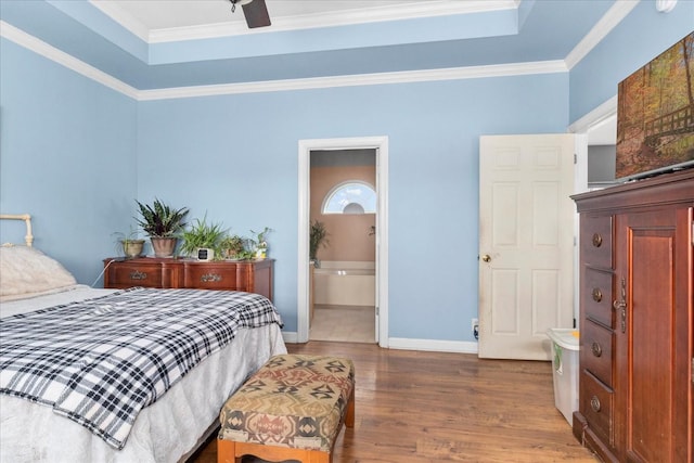 bedroom featuring a tray ceiling, wood-type flooring, ornamental molding, and ceiling fan