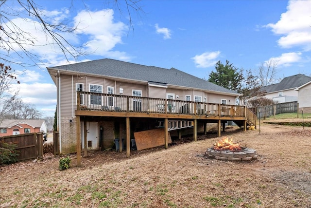 rear view of property featuring a wooden deck and an outdoor fire pit