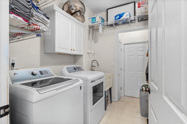 washroom with cabinets and washer and clothes dryer