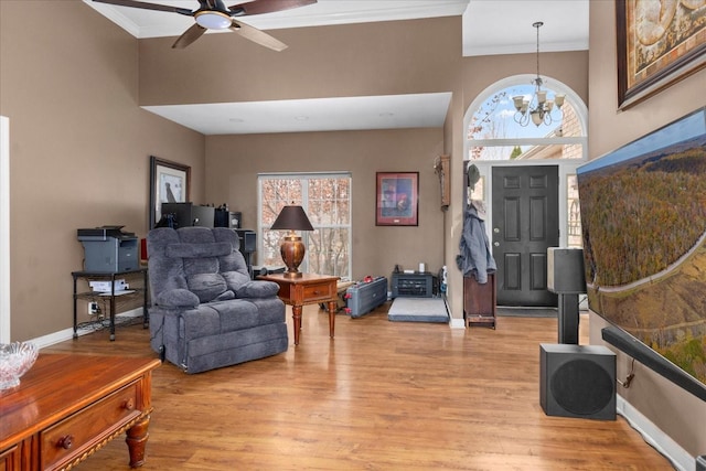 foyer with crown molding, a wealth of natural light, a high ceiling, and light wood-type flooring