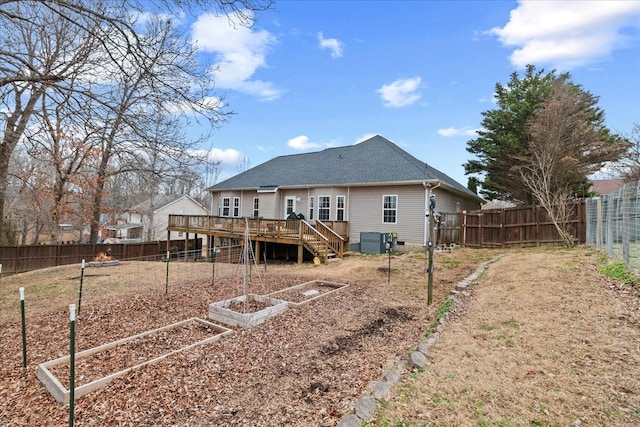 rear view of house with a wooden deck and cooling unit