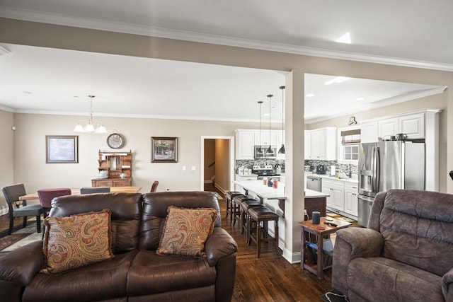 living room featuring crown molding, dark wood-type flooring, and a chandelier