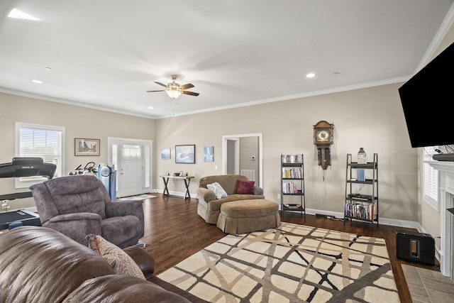 living room with wood-type flooring, ornamental molding, and ceiling fan