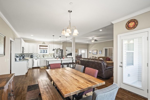 dining space with crown molding, an inviting chandelier, and dark hardwood / wood-style flooring