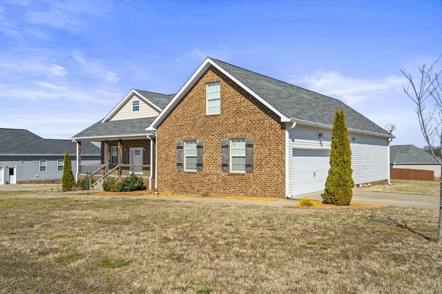 view of front of property featuring a garage, a front lawn, and covered porch