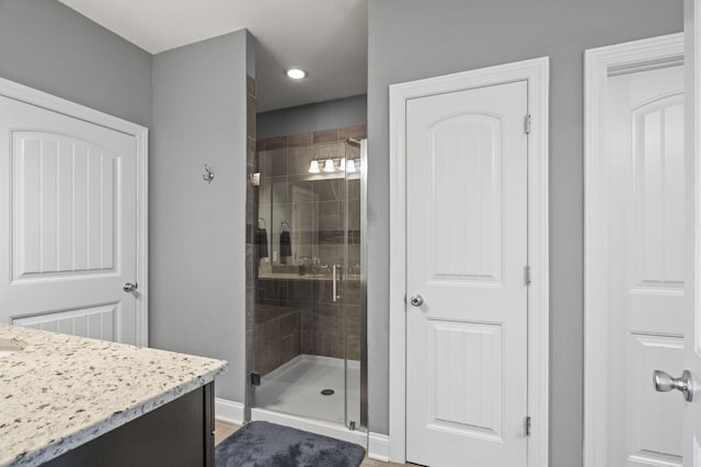 bathroom featuring vanity and a shower with door