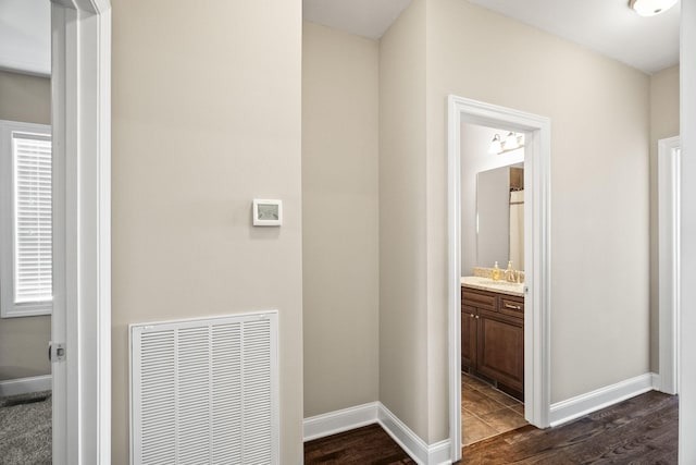 corridor with dark hardwood / wood-style floors and sink