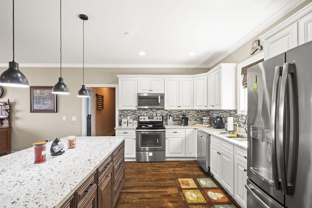 kitchen featuring appliances with stainless steel finishes, hanging light fixtures, and white cabinets