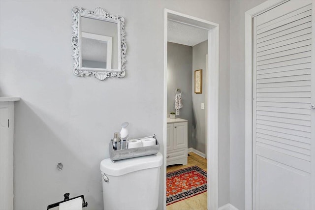 bathroom with vanity, a textured ceiling, and toilet