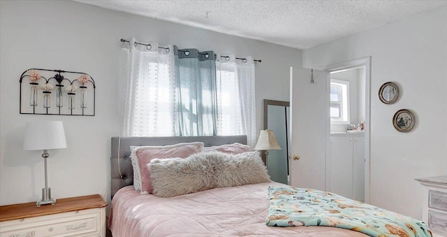 bedroom featuring multiple windows and a textured ceiling