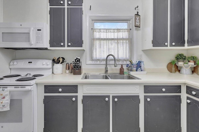 kitchen with white appliances, gray cabinets, and sink