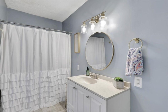 bathroom with vanity, a textured ceiling, and walk in shower