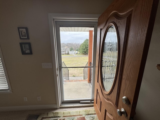 doorway to outside featuring carpet flooring