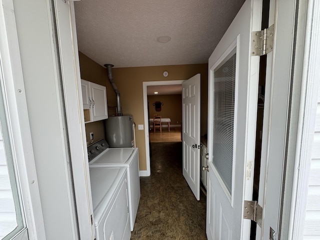 laundry room with a textured ceiling, gas water heater, cabinets, and washing machine and clothes dryer