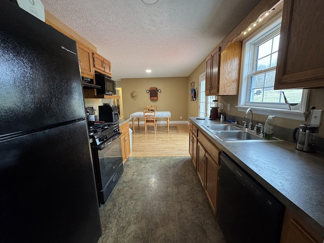 kitchen featuring extractor fan, sink, a textured ceiling, and black appliances