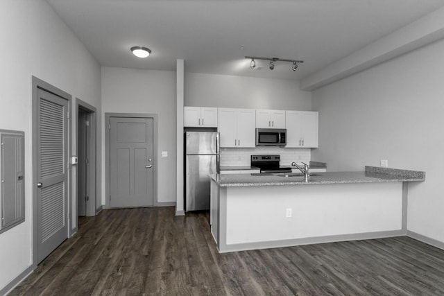 kitchen featuring sink, appliances with stainless steel finishes, tasteful backsplash, white cabinets, and kitchen peninsula